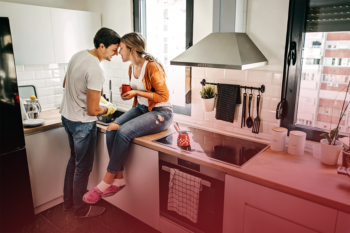 a couple in the kitchen sat around white goods